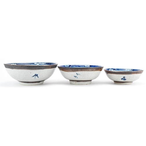 93 - Graduated set of three Chinese crackle glazed bowls hand painted with flowers and landscapes, the la... 