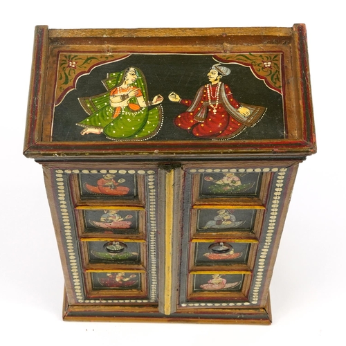 221 - Indian hardwood wall cupboard enclosing three shelves, hand painted with figures in traditional dres... 