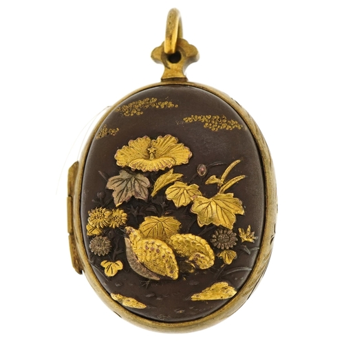 2086 - Japanese oval mixed metal locket with gilded relief birds, flowers and junk 3.7cm high, 16.5g