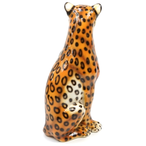 1237 - Large porcelain floor standing model of a seated leopard, 90cm high