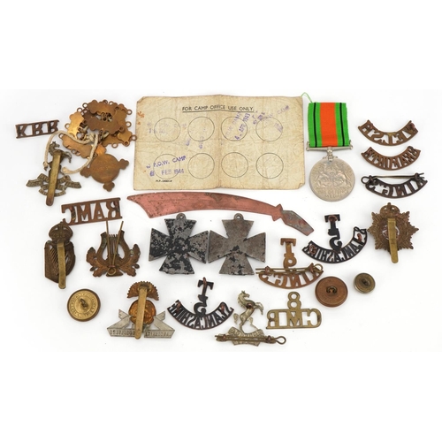 661 - British militaria including shoulder titles, cap badges and World War II Defence medal