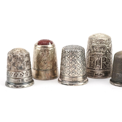 2752 - Eight silver thimbles including Elizabeth II Silver Jubilee and one with inset orange stone, the lar... 