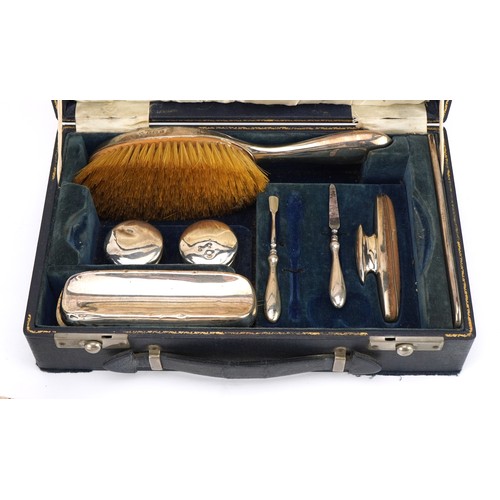 2715 - William Neale, George V silver travelling vanity set housed in a velvet and silk lined fitted case, ... 