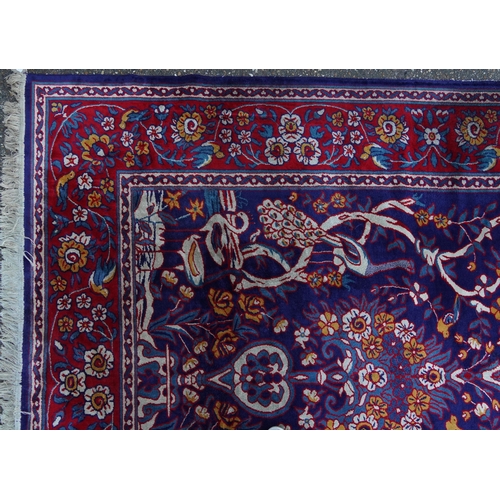 1046 - Rectangular Sarook Kashan silk rug decorated with birds amongst flowers onto a predominantly red and... 