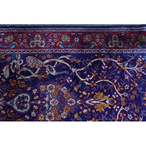 1046 - Rectangular Sarook Kashan silk rug decorated with birds amongst flowers onto a predominantly red and... 