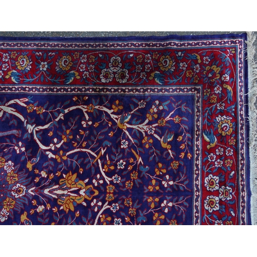 1046 - Rectangular Sarook Kashan silk rug decorated with birds amongst flowers onto a predominantly red and... 