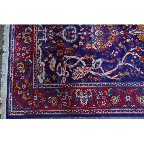 1046 - Rectangular Sarook Kashan silk rug decorated with birds amongst flowers onto a predominantly red and... 