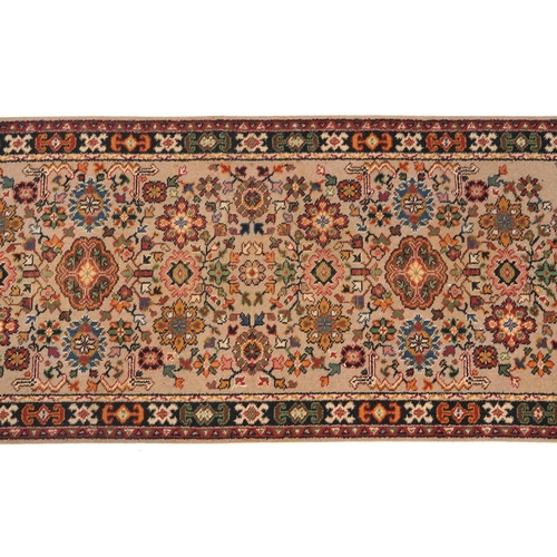 1055 - Rectangular floral carpet runner the central field having a beige ground, 270cm x 90cm