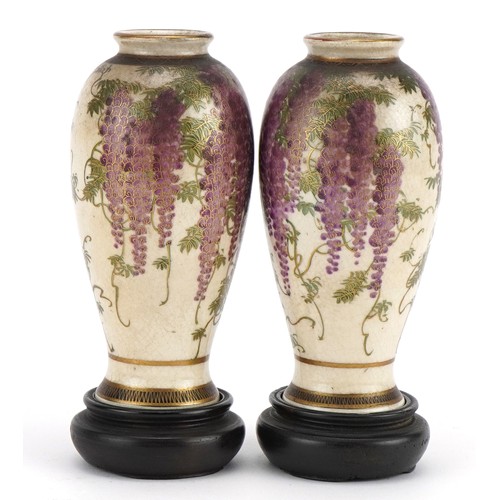 98 - Pair of Japanese Satsuma pottery vases   raised on hardwood stands each hand painted with wisteria, ... 