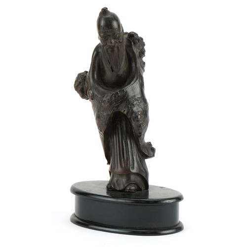 60 - Chinese root wood carving of an elder raised on a later oval ebonised base, overall 23.5cm high