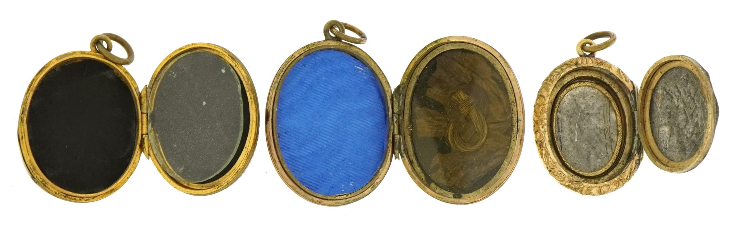 Three Victorian and later oval lockets comprising a yellow metal ...