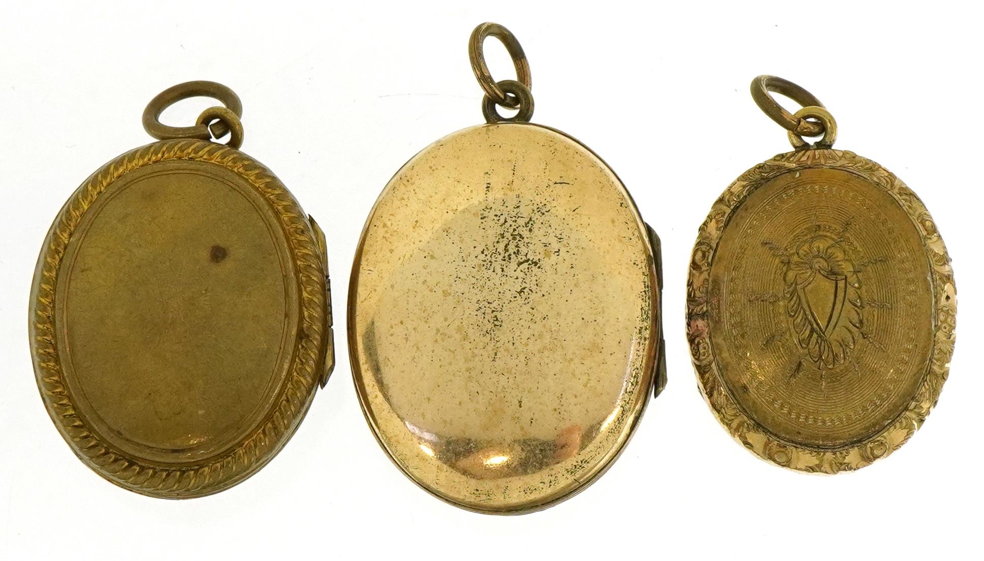 Three Victorian and later oval lockets comprising a yellow metal ...