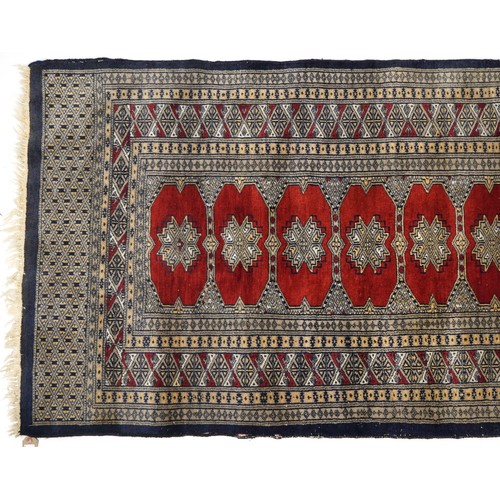 1035 - Rectangular red and blue ground rug with all over geometric design, 165cm x 92cm