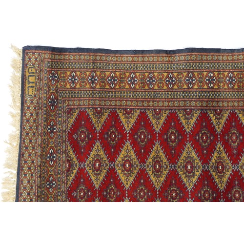 1069 - Rectangular red and blue ground rug with all over geometric design, 145cm x 91cm