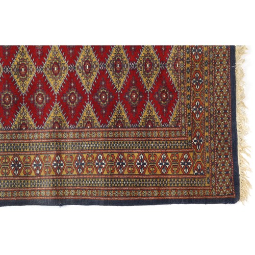 1069 - Rectangular red and blue ground rug with all over geometric design, 145cm x 91cm