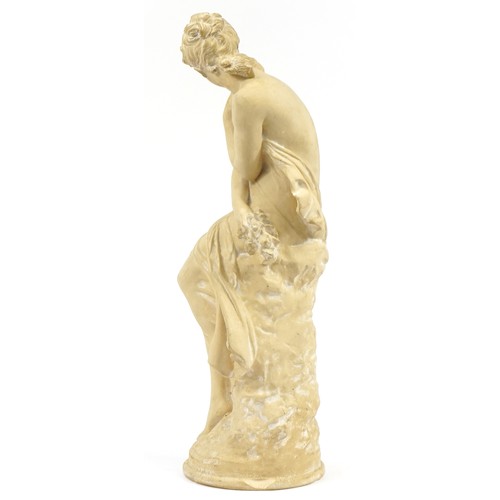 1234 - Large plaster figurine of a semi nude maiden seated on a rock, 65cm high