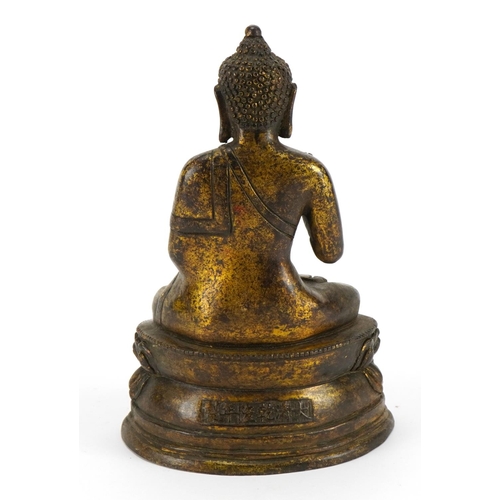 502 - Chino Tibetan partially gilt bronze figure of seated Buddha, character marks to the reverse, 19.5cm ... 