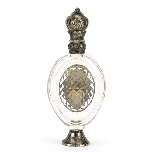 57 - Antique cut glass scent bottle with stopper and unmarked silver mounts, 10.2cm high