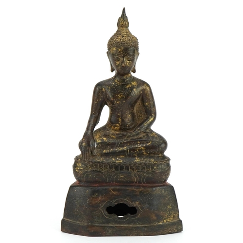 173 - South East Asian partially gilt patinated bronze figure of seated Buddha, 22cm high