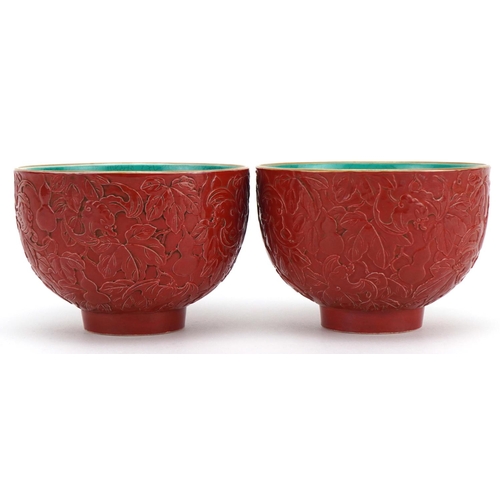 487 - Pair of Chinese faux cinnabar lacquer porcelain footed bowls decorated in low relief with bats and g... 