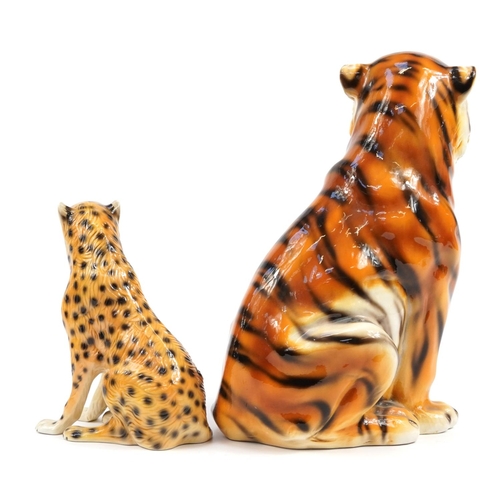 555 - Large ceramic model of a seated tiger and a similar example with a leopard, the largest 47cm high