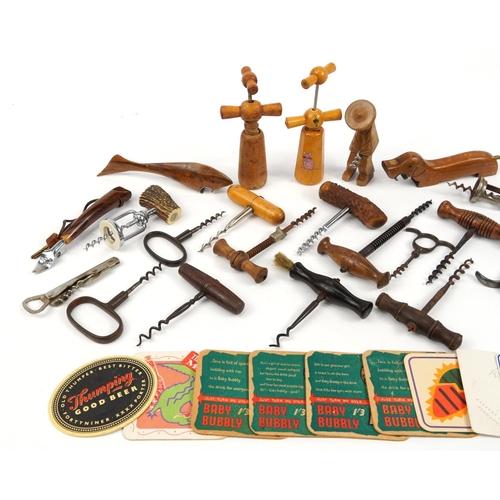 470 - Antique and later corkscrews, bottle openers and beer mats including an example with hardwood handle... 