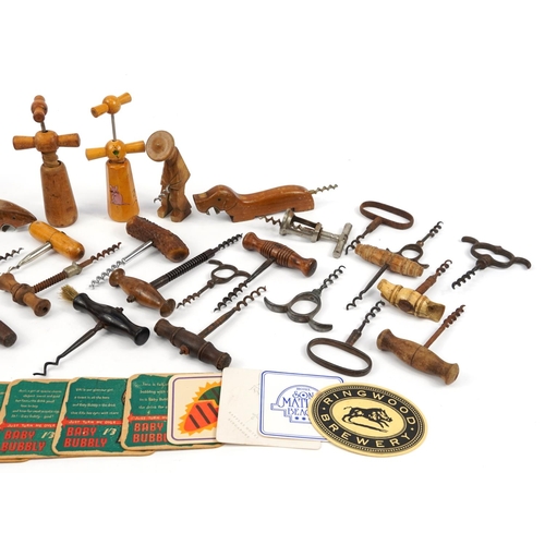 470 - Antique and later corkscrews, bottle openers and beer mats including an example with hardwood handle... 