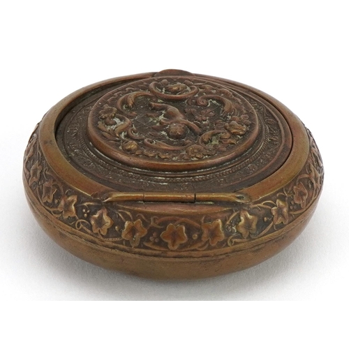 224 - 19th century circular brass snuff box with hinged lid, decorated in relief with Putti, 5cm in diamet... 