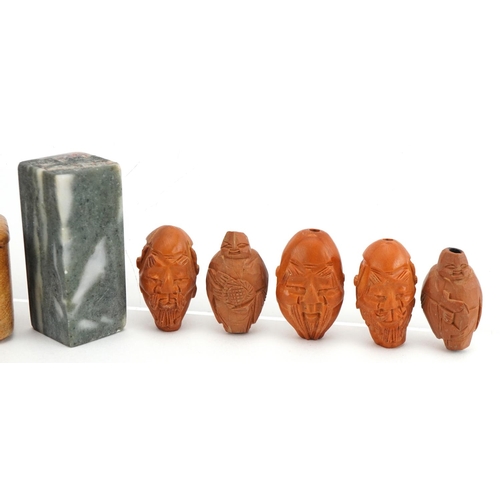 48 - Five Chinese carved coquilla nuts and a hardstone desk seal with calligraphy, with hardwood case hav... 