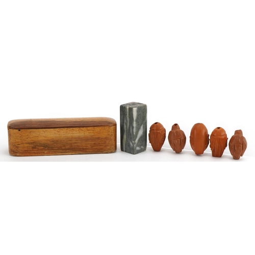 48 - Five Chinese carved coquilla nuts and a hardstone desk seal with calligraphy, with hardwood case hav... 