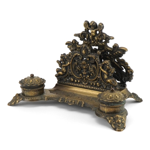 1283 - 19th century style brass desk stand decorated with Putti with letter rack and pair of inkwells, 30cm... 