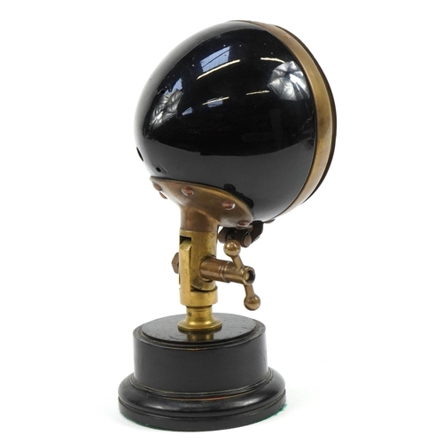 417 - Vintage CAM brass and black enamel fire engine headlight mounted on a circular plinth base, 35cm hig... 