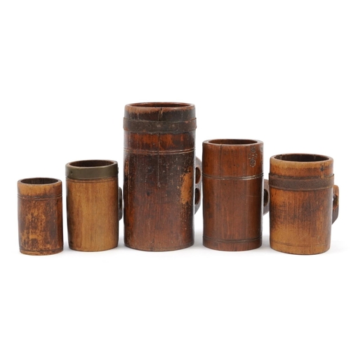 25 - Five antique Tudor style treen tankards including three metal bound, various impressed marks, the la... 