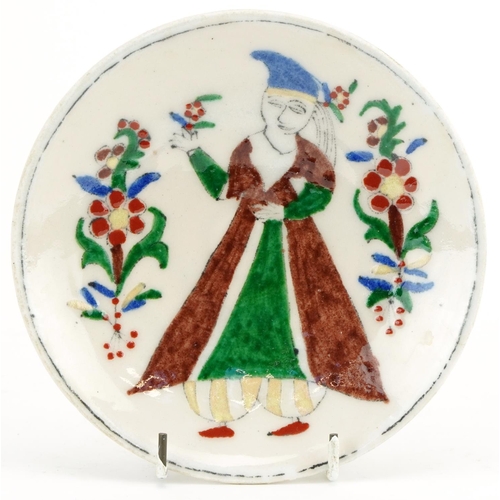 73 - Turkish Ottoman Kutahya plate hand painted with a figure wearing traditional dress, 15cm in diameter