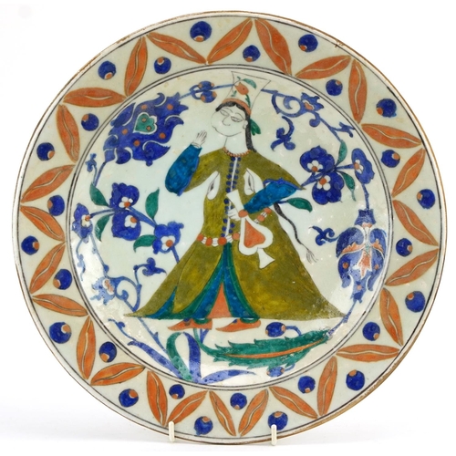 23 - Turkish Ottoman Iznik shallow dish hand painted with a figure wearing traditional dress amongst flow... 