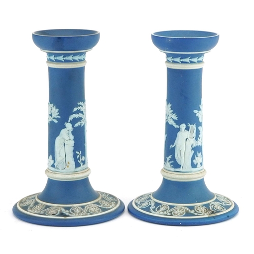 63 - Pair of Wedgwood Jasperware candlesticks decorated in low relief with tinged brown and classical fig... 