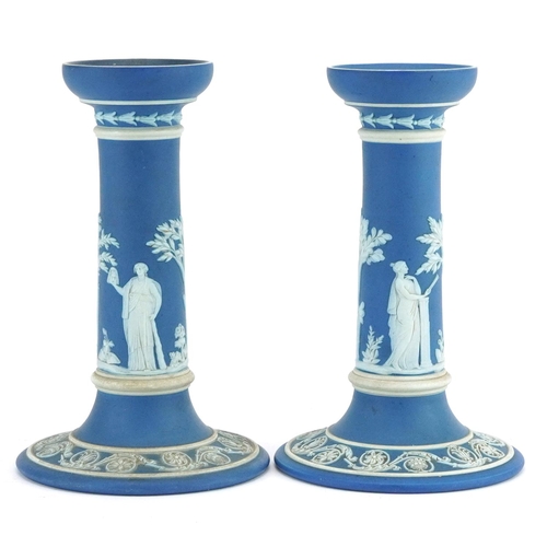 63 - Pair of Wedgwood Jasperware candlesticks decorated in low relief with tinged brown and classical fig... 