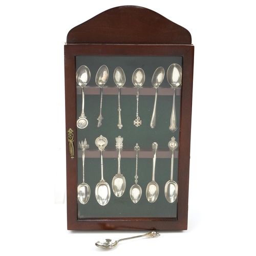 437 - Thirteen silver sporting and souvenir teaspoons housed in a mahogany display case, the largest 12.5c... 