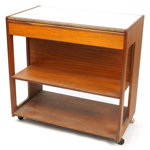 1038 - A H McIntosh & Co of Kirkcaldy Scotland, mid century teak trolley with open shelves and frieze drawe... 