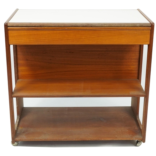 1038 - A H McIntosh & Co of Kirkcaldy Scotland, mid century teak trolley with open shelves and frieze drawe... 