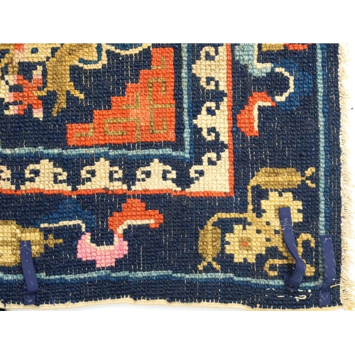 1030A - Chinese blue ground Saddle rug decorated with Daoist emblems and flowers, 120cm x 53cm