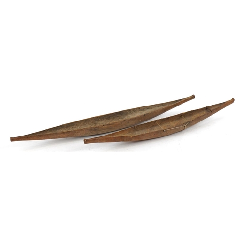 289 - Near pair of American Indian folk art carved wood canoes, the largest 52cm in length