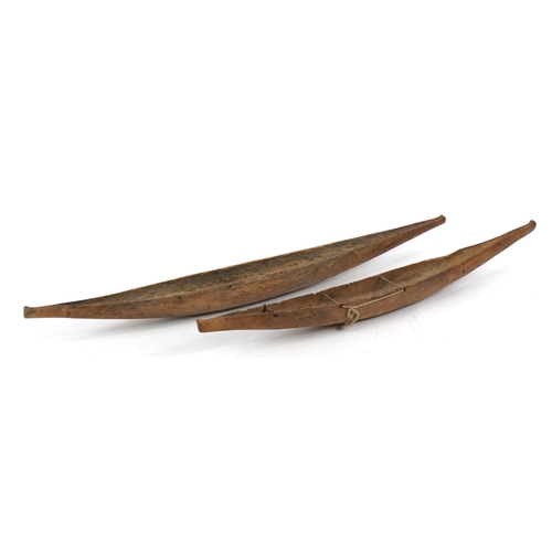 289 - Near pair of American Indian folk art carved wood canoes, the largest 52cm in length