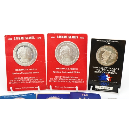 2412 - Six silver coins including two 1972 Cayman Islands twenty five dollars, 1983 Olympic dollar and 1970... 