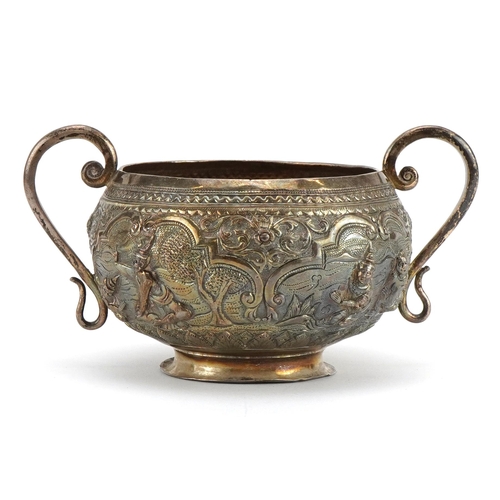 299 - Anglo Indian unmarked silver twin handled sugar bowl profusely embossed with figures praying, 13cm w... 