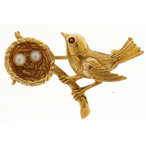 3016 - 9ct gold bird and nest brooch with two pearl eggs and a red stone eye, 3.3cm wide, 5.0g
