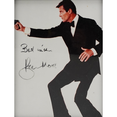 2483 - James Bond interest photograph of Roger Moore, signed in ink, framed and glazed, overall 32cm x 27cm