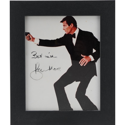 2483 - James Bond interest photograph of Roger Moore, signed in ink, framed and glazed, overall 32cm x 27cm