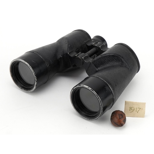 2181 - Pair of military interest World War II binoculars and a World War I nut carved with palm trees