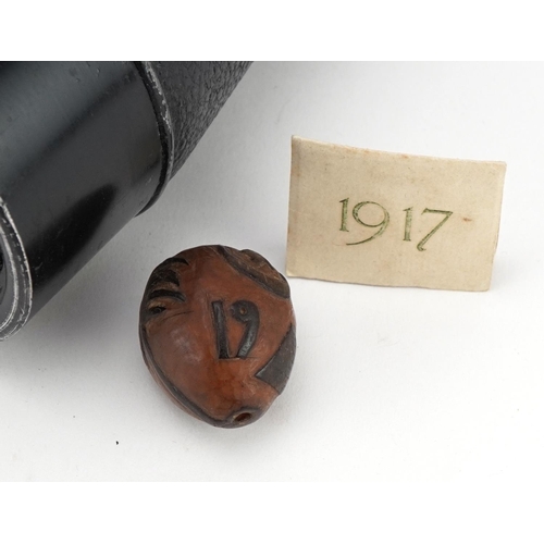 2181 - Pair of military interest World War II binoculars and a World War I nut carved with palm trees